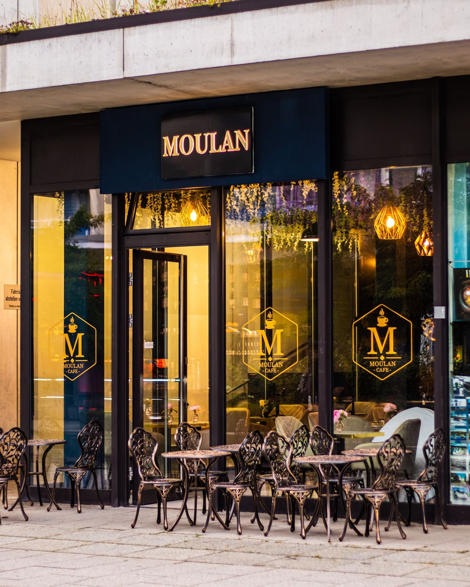 Moulan Café Außenansicht in der Abenddämmerung mit warmer Beleuchtung und Außenplätzen in Chemnitz